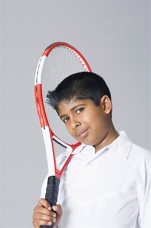 simsearch:630-02219279,k - Portrait of a boy holding a tennis racket over his shoulder Foto de stock - Royalty Free Premium, Número: 630-02220955