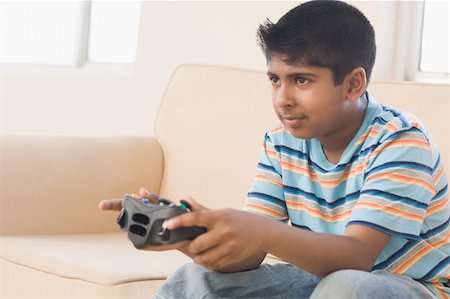 Boy sitting on a couch and playing video game Stock Photo - Premium Royalty-Free, Code: 630-02220953