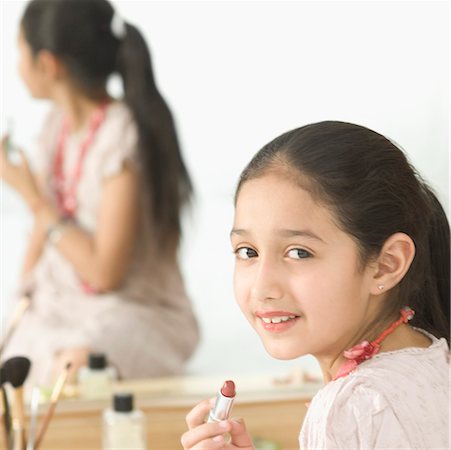 preteen in lipstick - Reflection of a girl applying lipstick in a dressing table mirror Foto de stock - Sin royalties Premium, Código: 630-02220984