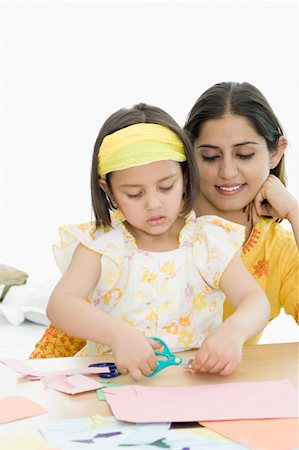 Girl cutting papers with scissors and her mother behind her Foto de stock - Sin royalties Premium, Código: 630-02221096