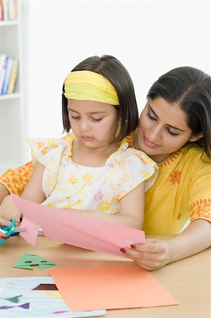 scissors papers - Young woman with her daughter cutting papers with scissors Stock Photo - Premium Royalty-Free, Code: 630-02221092