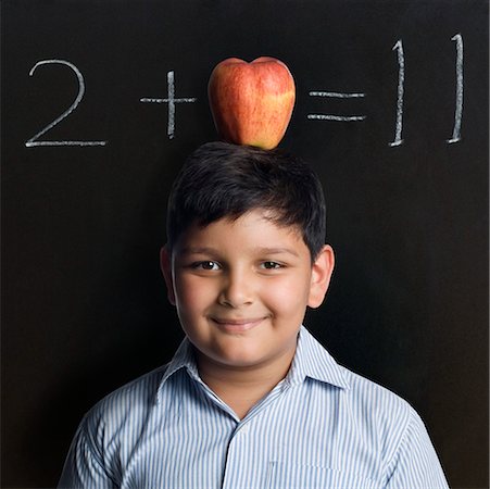 simsearch:630-02220721,k - Portrait of a boy balancing an apple on his head Foto de stock - Sin royalties Premium, Código: 630-02221115