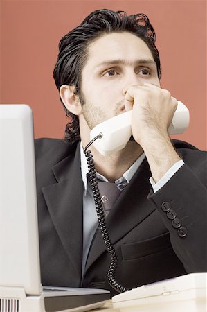 simsearch:630-02219583,k - Businessman holding a telephone receiver and thinking Stock Photo - Premium Royalty-Free, Code: 630-02221149