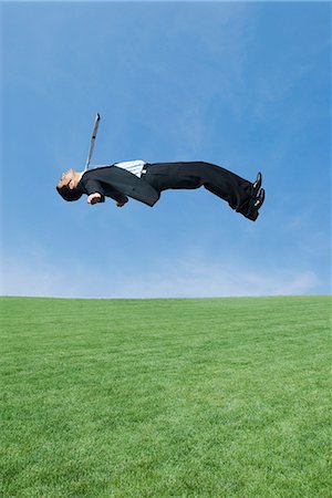 Side profile of a businessman in mid-air Stock Photo - Premium Royalty-Free, Code: 630-03479305