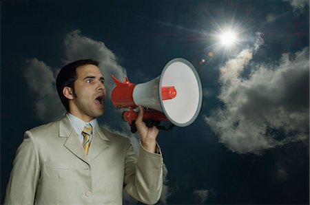 shouting man expression - Businessman shouting into a megaphone Stock Photo - Premium Royalty-Free, Code: 630-03479325