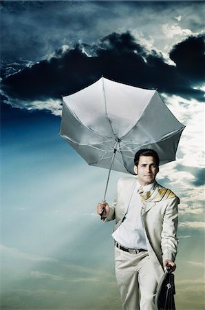 suit wind - Businessman holding an umbrella and walking Foto de stock - Sin royalties Premium, Código: 630-03479328