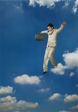 scared asian man - Businessman holding a briefcase and moving on clouds Stock Photo - Premium Royalty-Free, Code: 630-03479321