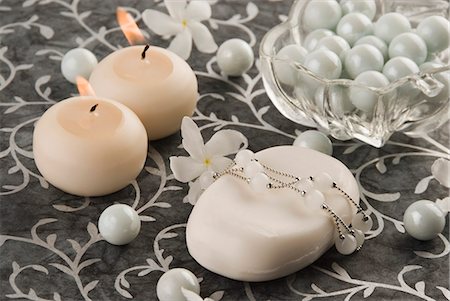 Close-up of a bar of soap with pearls and candles Stock Photo - Premium Royalty-Free, Code: 630-03479362