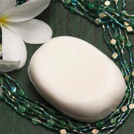 Close-up of a bar of soap with necklaces and a flower Stock Photo - Premium Royalty-Free, Code: 630-03479370