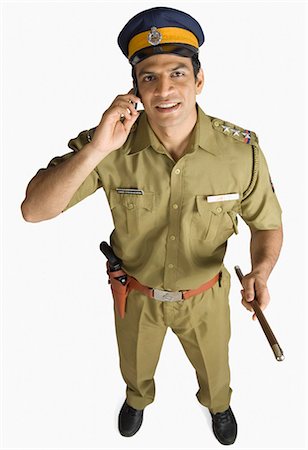 Portrait of a policeman talking on a mobile phone and smiling Stock Photo - Premium Royalty-Free, Code: 630-03479405