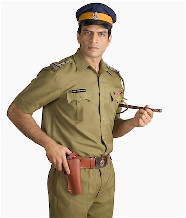 Portrait of a policeman holding a handgun Stock Photo - Premium Royalty-Free, Code: 630-03479400