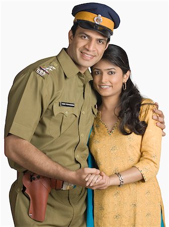 picture of a policeman with a handgun - Portrait of a police officer standing with his arm around his wife Stock Photo - Premium Royalty-Free, Code: 630-03479466