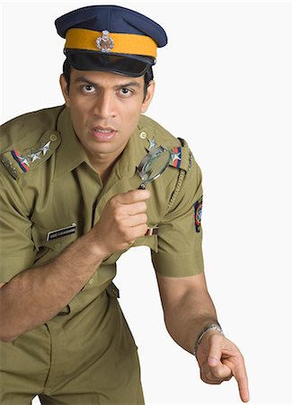 proud young man - Police officer holding a magnifying glass Stock Photo - Premium Royalty-Free, Code: 630-03479461