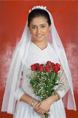 Portrait of a newlywed bride holding a bouquet of flowers and smiling Stock Photo - Premium Royalty-Free, Code: 630-03479510