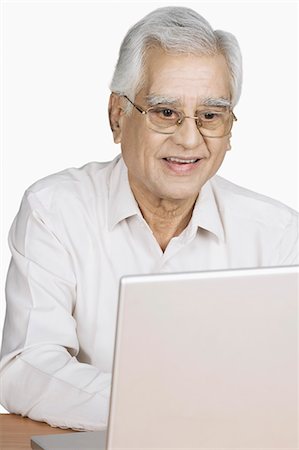 simsearch:630-03479698,k - Senior man using a laptop and smiling Stock Photo - Premium Royalty-Free, Code: 630-03479588
