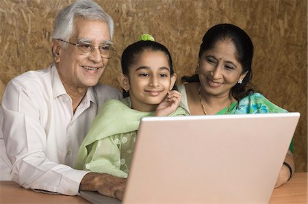Girl using a laptop with her grandparents Stock Photo - Premium Royalty-Free, Code: 630-03479605