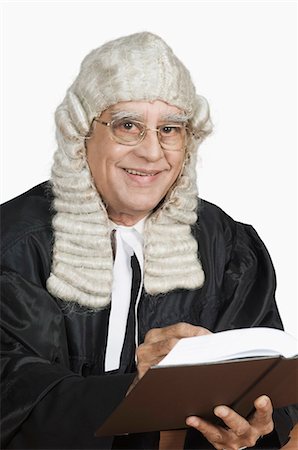 Portrait of a magistrate holding a book and smiling Stock Photo - Premium Royalty-Free, Code: 630-03479617
