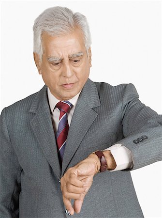 east indian businessman white background - Close-up of a businessman checking the time Stock Photo - Premium Royalty-Free, Code: 630-03479647