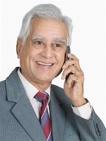 Homme d'affaires parlant sur un téléphone mobile et souriant Photographie de stock - Premium Libres de Droits, Code: 630-03479651