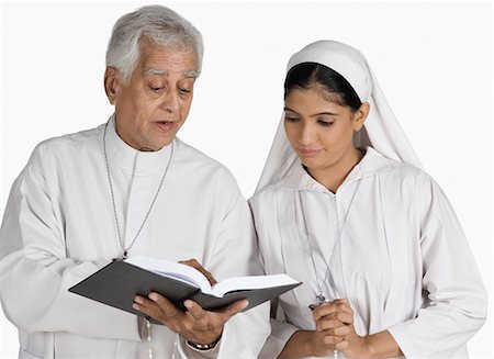 Priest and a nun looking at the Bible Foto de stock - Sin royalties Premium, Código: 630-03479694