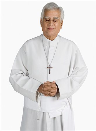 priest - Close-up of a priest standing with hands clasped and smiling Stock Photo - Premium Royalty-Free, Code: 630-03479704