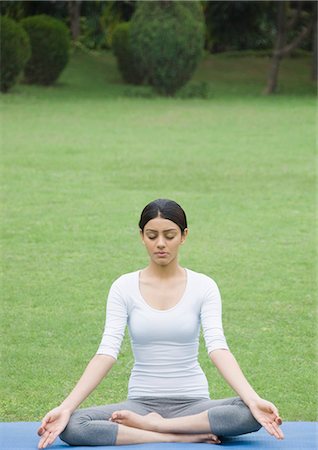 picture of a girl sitting in padmasana - Woman practicing yoga in a park Stock Photo - Premium Royalty-Free, Code: 630-03479789