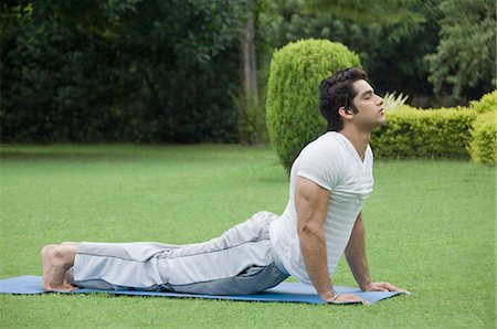 Side profile of a man exercising on an exercise mat Foto de stock - Royalty Free Premium, Número: 630-03479797