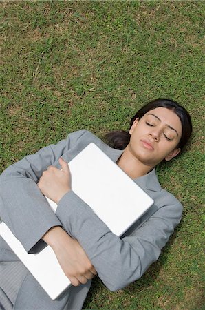 simsearch:630-03479873,k - Businesswoman lying on grass and hugging a laptop Foto de stock - Sin royalties Premium, Código: 630-03479826