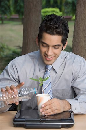 people workers tending tree - Businessman watering a plant Stock Photo - Premium Royalty-Free, Code: 630-03479867