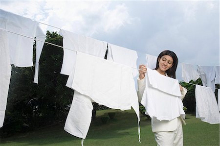 Businesswoman hanging washed cloths before going to work Foto de stock - Sin royalties Premium, Código: 630-03479877