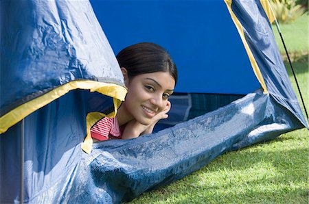 Woman lying in a tent and smiling Stock Photo - Premium Royalty-Free, Code: 630-03479908