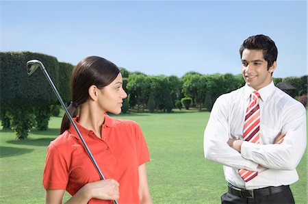 Couple standing in a golf course Stock Photo - Premium Royalty-Free, Code: 630-03479903