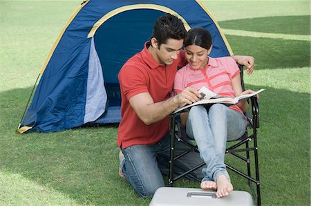 Couple reading a magazine in a park Stock Photo - Premium Royalty-Free, Code: 630-03479911