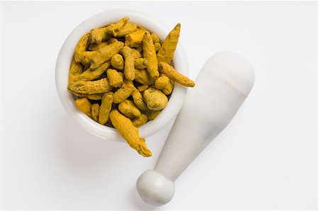 Racines de curcuma dans un mortier et un pilon Photographie de stock - Premium Libres de Droits, Code: 630-03480042