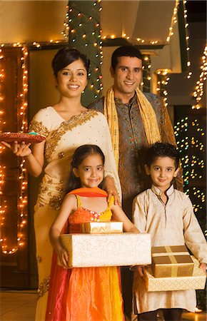 deepawali celebration girls - Children holding gifts with their parents holding religious offering Stock Photo - Premium Royalty-Free, Code: 630-03480223