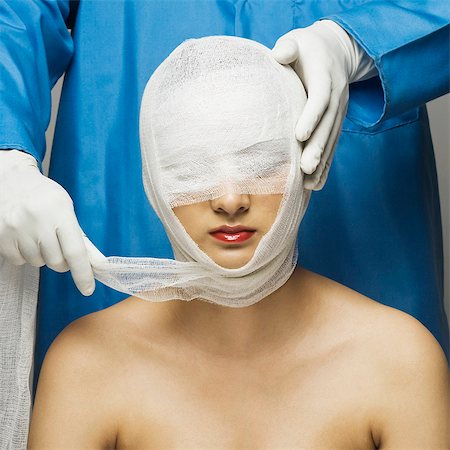 Surgeon wrapping bandage on woman's face Foto de stock - Sin royalties Premium, Código: 630-03480273