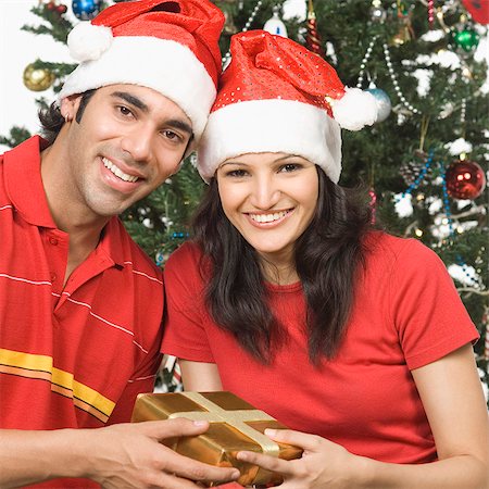 simsearch:630-03480424,k - Portrait of a couple holding a Christmas present and smiling Foto de stock - Sin royalties Premium, Código: 630-03480411