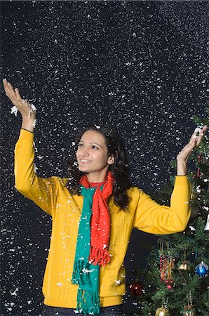 Woman standing in snow near a Christmas tree Stock Photo - Premium Royalty-Free, Code: 630-03480431