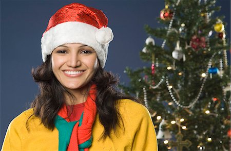 single christmas ball ornament - Portrait of a woman smiling near a Christmas tree Stock Photo - Premium Royalty-Free, Code: 630-03480446