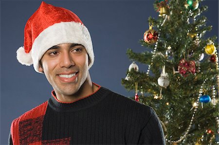 simsearch:630-03480395,k - Close-up of a man smiling near a Christmas tree Foto de stock - Sin royalties Premium, Código: 630-03480447