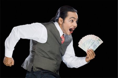 funny black man - Close-up of a mime running with currency notes Stock Photo - Premium Royalty-Free, Code: 630-03480598