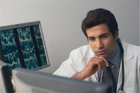 stethoscope check up indian photos - Male doctor examining an X-Ray report Stock Photo - Premium Royalty-Free, Code: 630-03480715