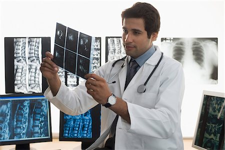 stethoscope check up indian photos - Male doctor examining an X-Ray report Foto de stock - Sin royalties Premium, Código: 630-03480724
