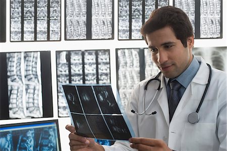 surgeon male young - Male doctor examining an X-Ray report Stock Photo - Premium Royalty-Free, Code: 630-03480726