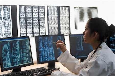 Female doctor examining an X-Ray report Foto de stock - Sin royalties Premium, Código: 630-03480743