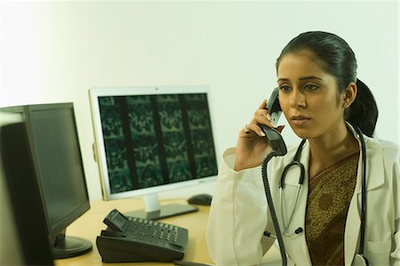 simsearch:6108-06168441,k - Female doctor examining an X-Ray and talking on the telephone Stock Photo - Premium Royalty-Free, Code: 630-03480756