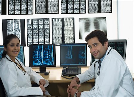 simsearch:630-03480875,k - Portrait of a female doctor smiling with a male doctor Foto de stock - Sin royalties Premium, Código: 630-03480759