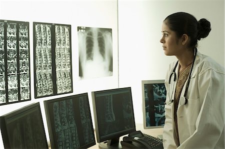 simsearch:630-03480765,k - Female doctor examining an X-Ray report Foto de stock - Sin royalties Premium, Código: 630-03480750
