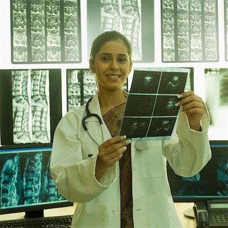 simsearch:625-02929220,k - Portrait of a female doctor holding an X-Ray report and smiling Stock Photo - Premium Royalty-Free, Code: 630-03480752