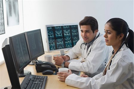 Female doctor with a male doctor examining an X-Ray report Foto de stock - Sin royalties Premium, Código: 630-03480766